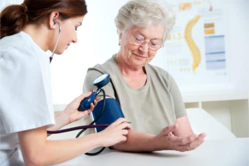 Ärztin misst den Blutdruck bei Seniorin